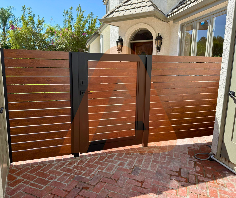 Real installed woodgrain aluminum sliding privacy gate with black structural frame