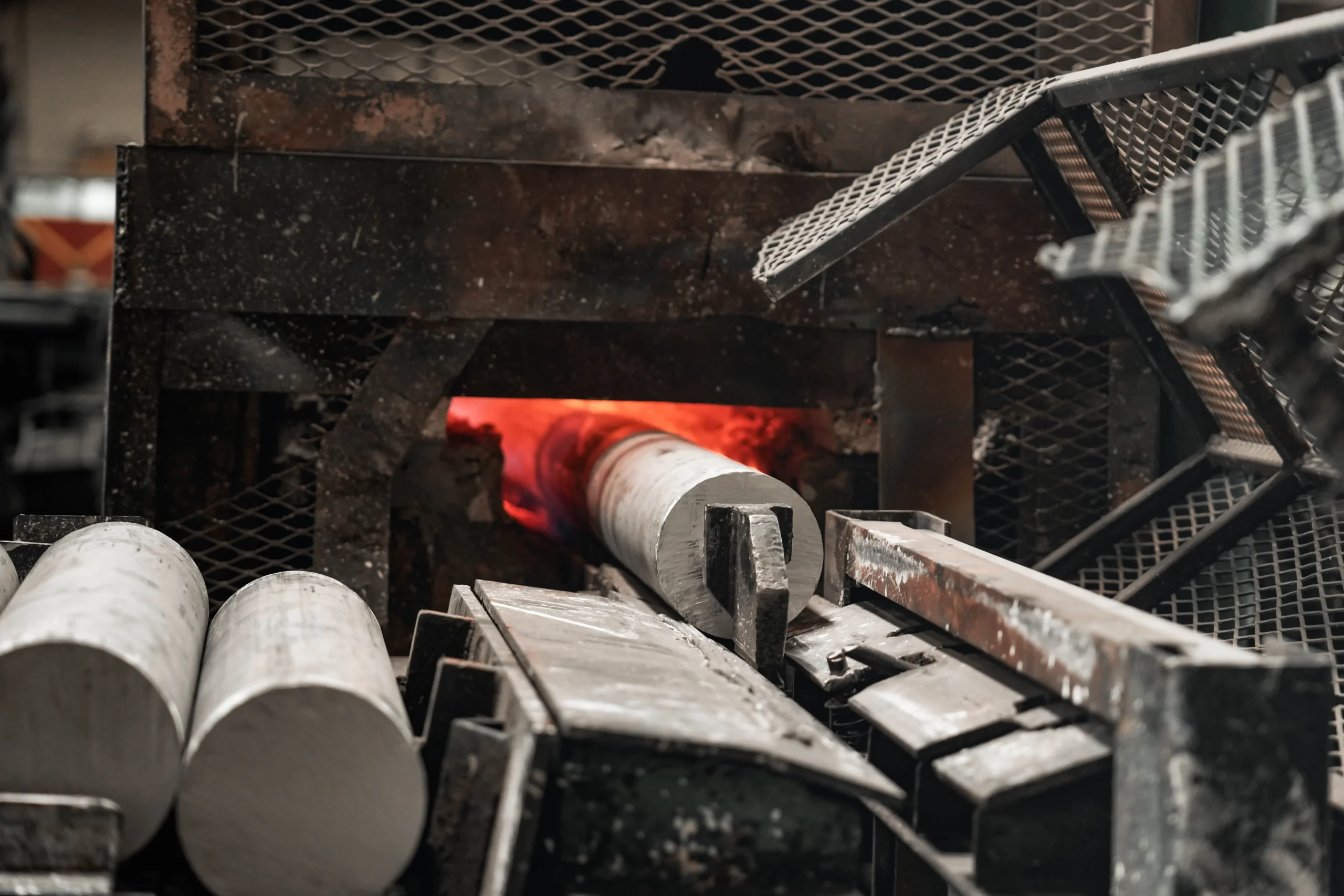 Architectural aluminum billet entering an extrusion press during manufacturing