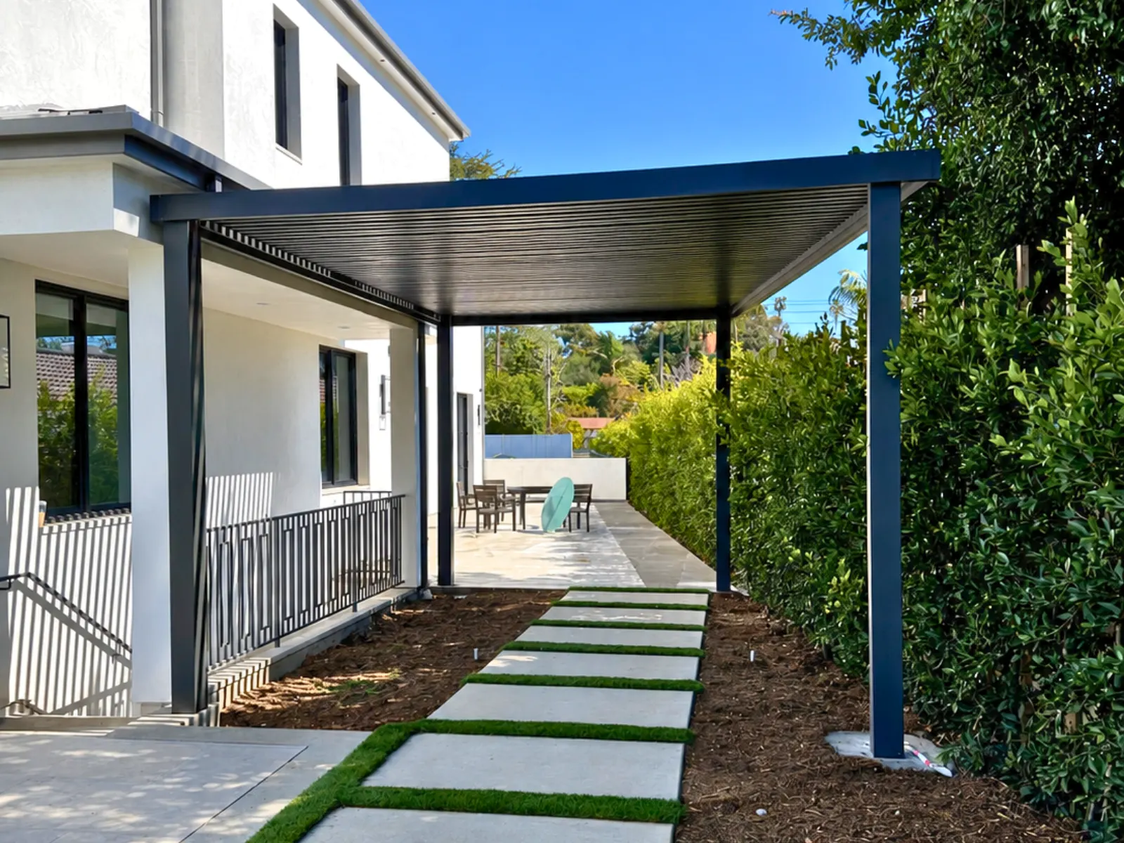 Architectural aluminum slat patio cover integrated with a modern home